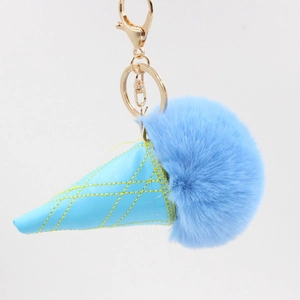 Close-up of fluffy blue pompom ice cream keychain with stitched leather cone and gold clasp