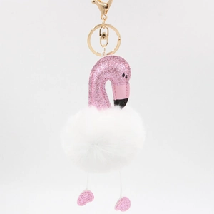 Détail de flamant rose à paillettes et pompon blanc en peluche avec porte-clé doré