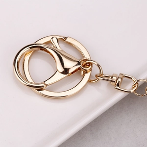 Macro shot of polished gold-plated metal lobster clasp and ring connector hardware