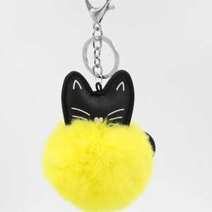 Detail of cute cat plush ball keychain with black PU leather and yellow faux fur