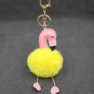 Détail de porte-clés flamant avec tête en cuir, pompon jaune et crochet doré élégant