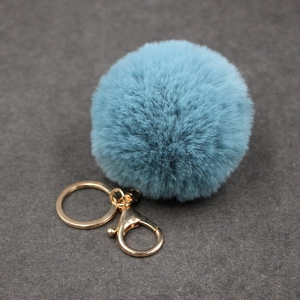 Détail d'un porte-clés en fausse fourrure bleu clair avec un fermoir doré brillant