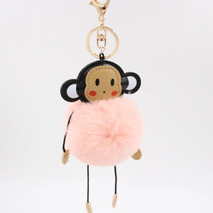 Detailed view of pink monkey plush keychain with fluffy fur pompom and metal gold ring