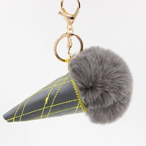 Detail of grey faux fur ice cream keychain with yellow stitching on dark grey leather cone