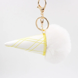 Detail of white plush ice cream keychain with yellow grid stitching and gold lobster clasp