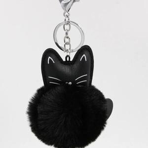 Detail of black PU leather cat keychain with soft faux fur pom-pom and silver metal clasp