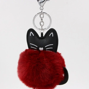 Detail of red faux fur pompom with black PU leather cat head and silver metal clasp