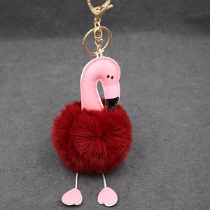 Détail du porte-clés flamant rose avec pompon rouge foncé et fermoir mousqueton doré