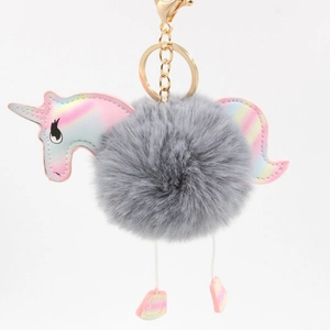 Detailed view of grey plush pompom unicorn charm with iridescent leather and gold hardware