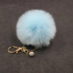 Close-up of light blue faux fur keychain with gold lobster clasp and rhinestone ball