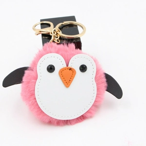 Détail du porte-clés pingouin en peluche rose avec fermoir en métal doré sur fond blanc
