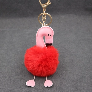 Détail d'un porte-clés flamant rose en cuir avec pompon rouge et fermoir en métal doré