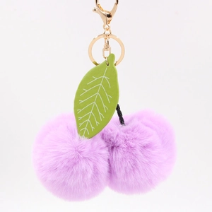 Détail du porte-clés cerise en fausse fourrure violette avec feuille et fermoir doré