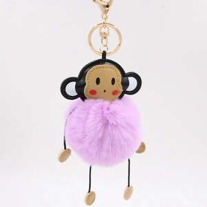 Cute cartoon monkey keychain with purple faux fur ball and gold metal clasp on white back