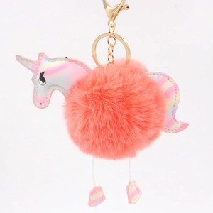 Detail of coral pink plush unicorn keychain with iridescent faux leather and gold clasp