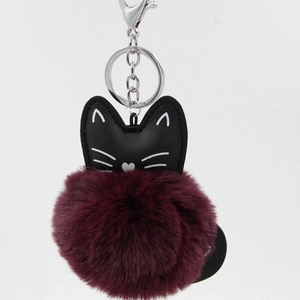 Close-up of black PU leather cat keychain with a soft wine red faux fur pompom ball