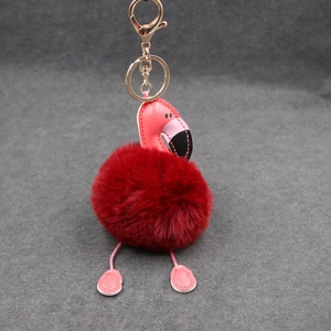 Détail du porte-clés flamant rose en fourrure rouge avec fermoir doré et détails cuir