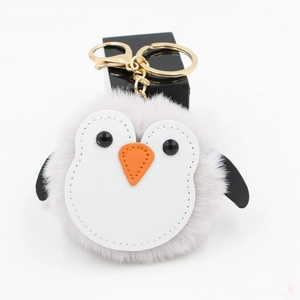 Vue détaillée du porte-clés pompon pingouin en peluche avec fermoir mousqueton doré