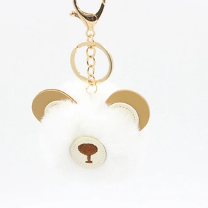 Close-up of fluffy white bear keychain with brown accents and gold metal ring