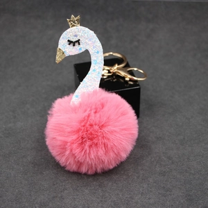 Close-up of pink fluffy swan keychain with gold crown and sparkling silver accents