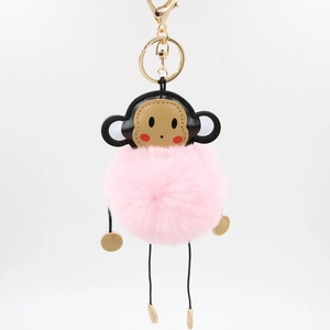 Detail of pink monkey faux fur pompom keychain with golden metal clasp and leather face