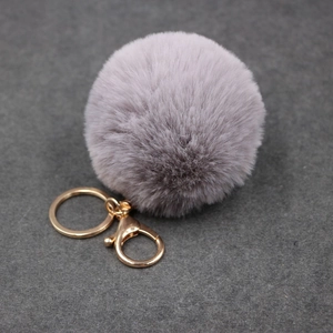 Détail du pompon en fausse fourrure gris-violet de 8cm avec fermoir doré en métal