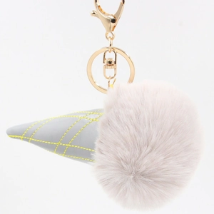 Close-up of ice cream keychain with pink faux fur pompom and gray leather cone details