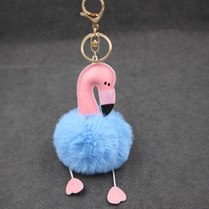 Détail du porte-clés flamant rose doré avec pompon en fausse fourrure bleu ciel