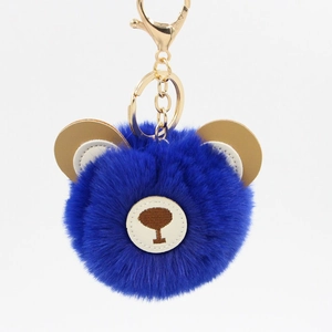 Detail of bright blue fluffy bear keychain with gold metallic clasp and faux rabbit fur