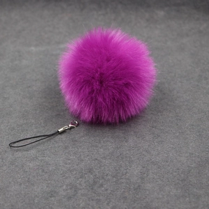 Detail of soft purple faux rabbit fur pompom keychain with silver lobster clasp and strap