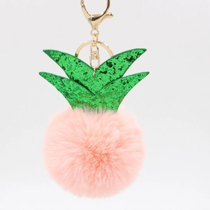 Close-up of pink faux fur pineapple keychain with green glitter leaves and gold clasp