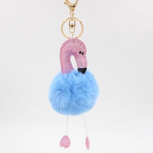 Détail de flamant rose à paillettes avec pompon en fausse fourrure bleue et porte-clés doré