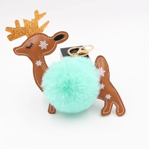 Close-up of reindeer keychain with green faux fur pompom and golden glitter antlers