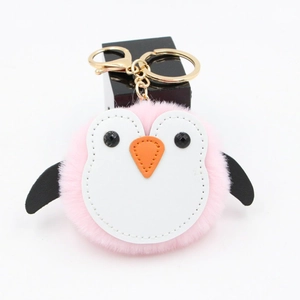 Détail d'un porte-clés pingouin en peluche rose avec boucle et anneau en métal doré