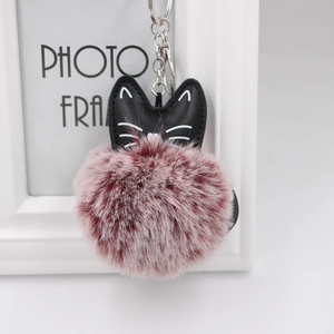 Detail view of fluffy faux fur pompom with leather cat ears and silver keychain clip