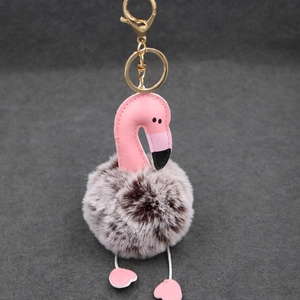 Détail de tête de flamant en similicuir rose et porte-clés doré sur pompon en fourrure douce