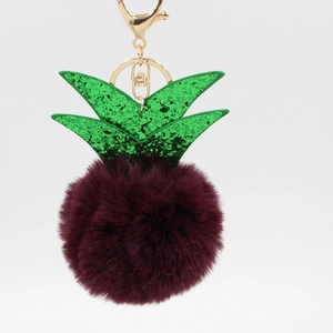 Detailed macro view of plush burgundy pineapple keychain with sparkly green leaves