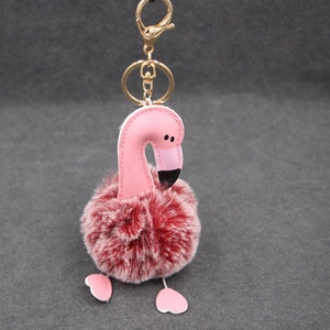 Détail du porte-clés flamant rose en peluche avec fermoir doré et boule de fausse fourrure