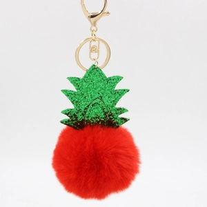 Detail of red plush pineapple keychain with green sequins and golden metal clasp