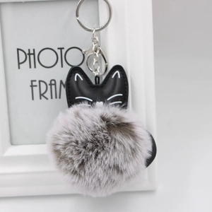 Close-up of a black PU leather cat charm with a fluffy gray faux fur pompom keychain