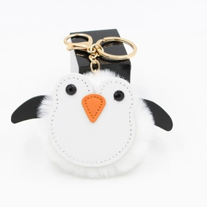 Détail d'un porte-clés pingouin en peluche avec fermoir doré et fourrure synthétique blanche