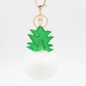 Detail of glitter green leaves and soft white pom-pom pineapple shaped keychain