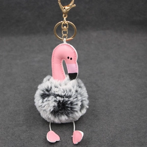 Détail du porte-clés flamant rose avec pompon en fausse fourrure, pieds cœur et fermoir doré