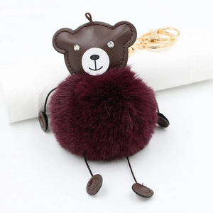 Detail view of burgundy faux fur bear keychain with sparkling diamond eyes and gold clasp