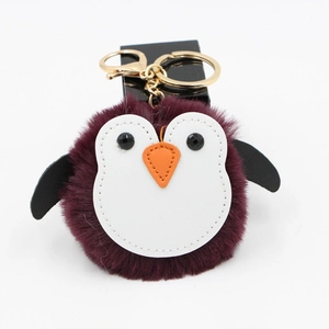Détail du porte-clés pingouin en peluche bordeaux avec fermoir en métal doré brillant