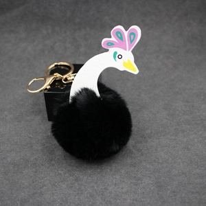 Détail d'un porte-clés cygne noir en fausse fourrure avec fermoir métallique doré chic