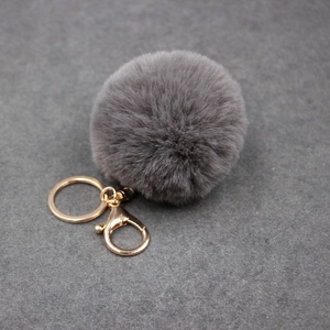 Détail d'un porte-clés en fausse fourrure gris foncé avec fermoir doré chic
