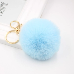 Cute light blue faux fur pompom keychain with golden lobster clasp on a white background