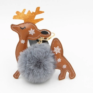 Detail of Christmas reindeer keychain with grey faux fur pom pom and orange sequins