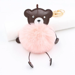 Detail of pink faux fur bear keychain with brown leather head and gold metal ring